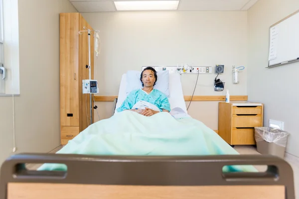 Retrato del paciente masculino que retrocede en la cama del hospital — Foto de Stock