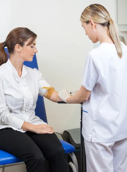 Krankenschwester entnimmt Blut am Arm der Geschäftsfrau — Stockfoto