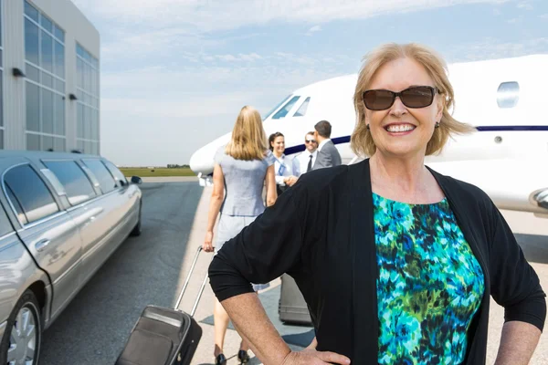 Счастливая бизнесвумен против частного самолета — стоковое фото