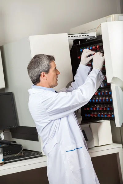Técnico colocando botellas en el instrumento de cultivo de sangre —  Fotos de Stock
