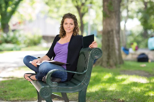 Αυτοπεποίθηση φοιτητής κάθεται σε παγκάκι στην πανεπιστημιούπολη — Φωτογραφία Αρχείου