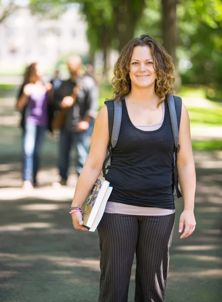 Student z plecaka i książki stojący na terenie kampusu — Zdjęcie stockowe