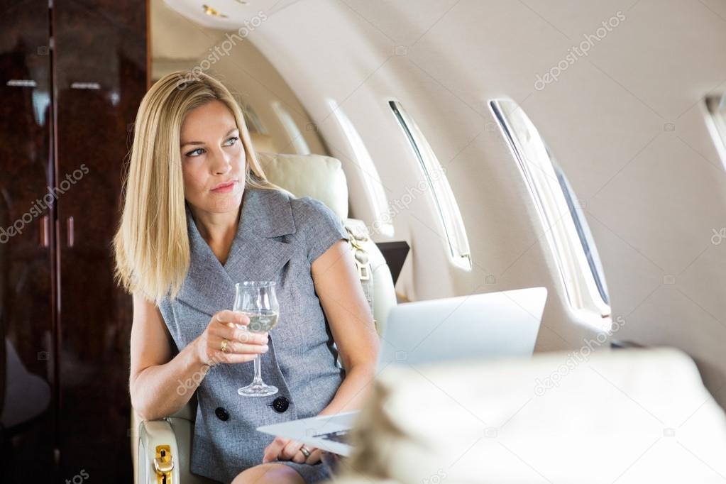 Businesswoman Looking Through Window Of Private Jet