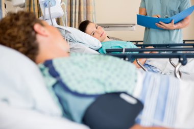 Patient's Looking At Each Other In Hospital Ward clipart