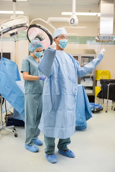 Nurse Assisting Surgeon With Sterile Gown — Stock Photo, Image