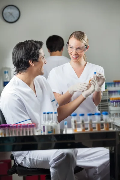 Técnicos felizes analisando a amostra no laboratório — Fotografia de Stock
