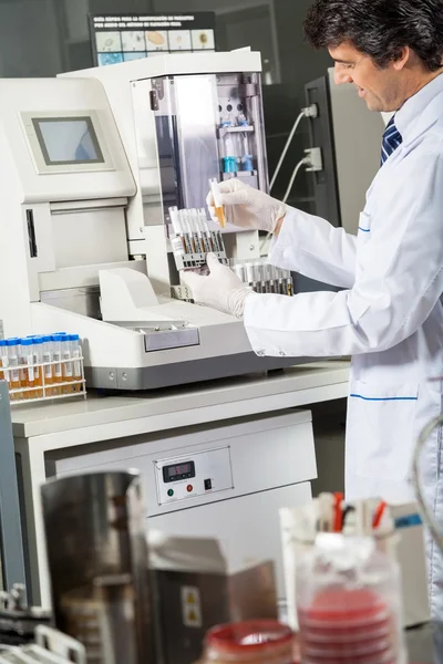 Scienziato che utilizza l'analizzatore di urina per testare i campioni — Foto Stock