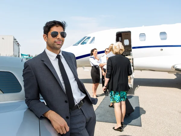 Businessman Leaning On Car At Airport Terminal — Stock Photo, Image