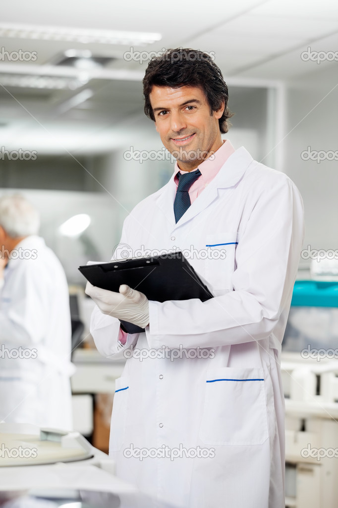 Technician With Clipboard In Laboratory