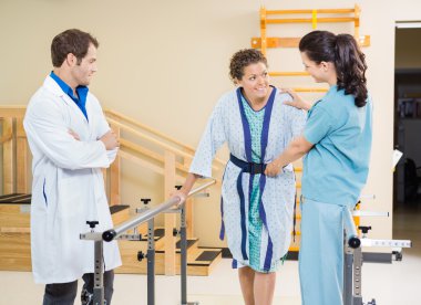 Female Patient Being Assisted By Physical Therapists
