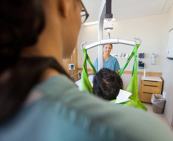 Krankenschwester lächelt mit Patient auf hydraulischem Lift — Stockfoto