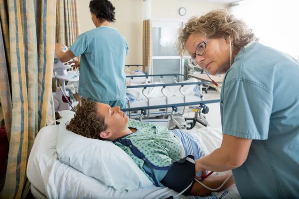Sjuksköterska kontrollera patientens blodtryck — Stockfoto