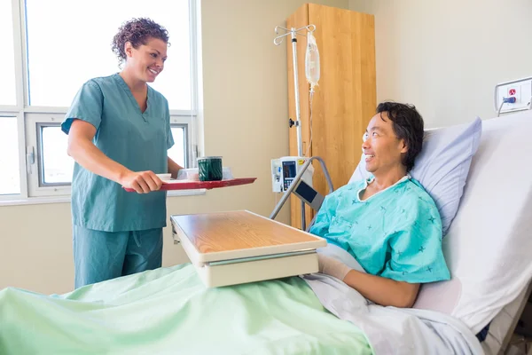 Vriendelijke verpleegster brengen ontbijt voor patiënt in het ziekenhuis — Stockfoto