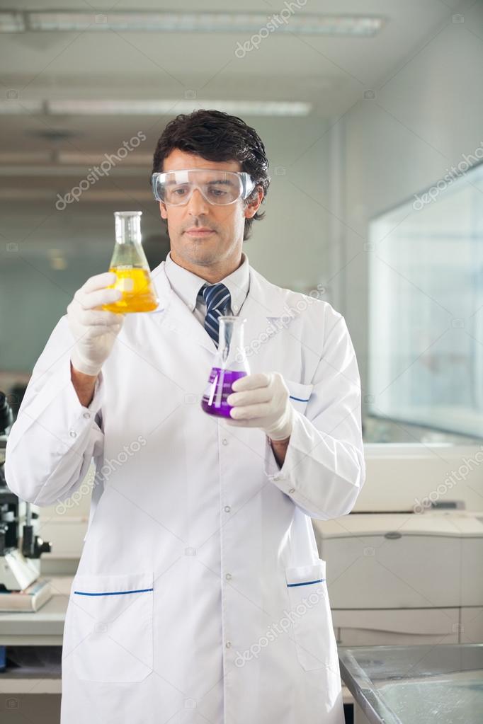 Scientist Examining Flasks With Different Chemicals