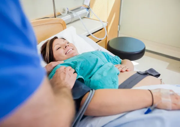 Mujer embarazada feliz acostada en la cama del hospital —  Fotos de Stock