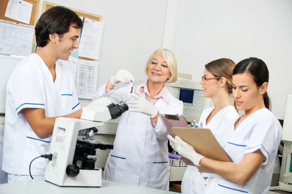 Cientistas discutindo sobre amostra de sangue em laboratório — Fotografia de Stock