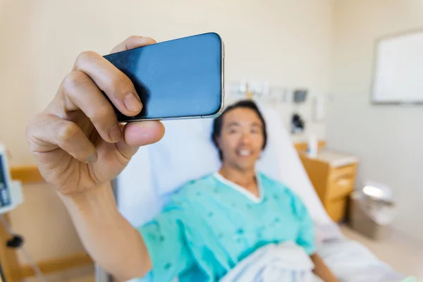 Paziente maschio che si autoritratto attraverso il telefono cellulare in Hospit — Foto Stock