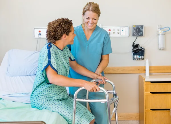 Enfermera que asiste al paciente usando el marco que camina en hospital —  Fotos de Stock