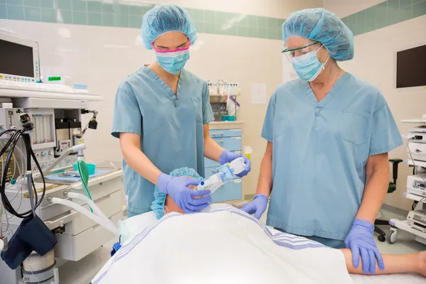 Verpleegkundigen zuurstof masker zetten patiënt — Stockfoto