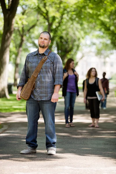 Säker manlig student på stående campus road — Stockfoto