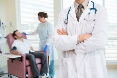 Doktor ayakta kolları kemoterapi odasında geçti.