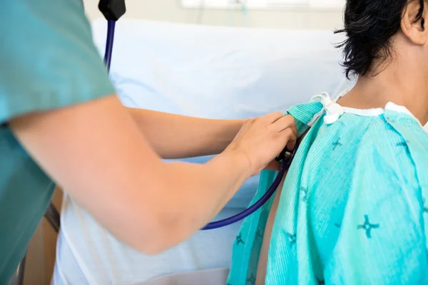 Krankenschwester untersucht Rücken der Patientin mit Stethoskop — Stockfoto