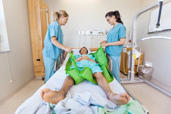 Медсестры готовят пациента мужского пола перед переводом на гидравлику. — стоковое фото