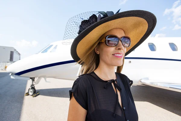 Богатая женщина, противостоящая частному самолету — стоковое фото