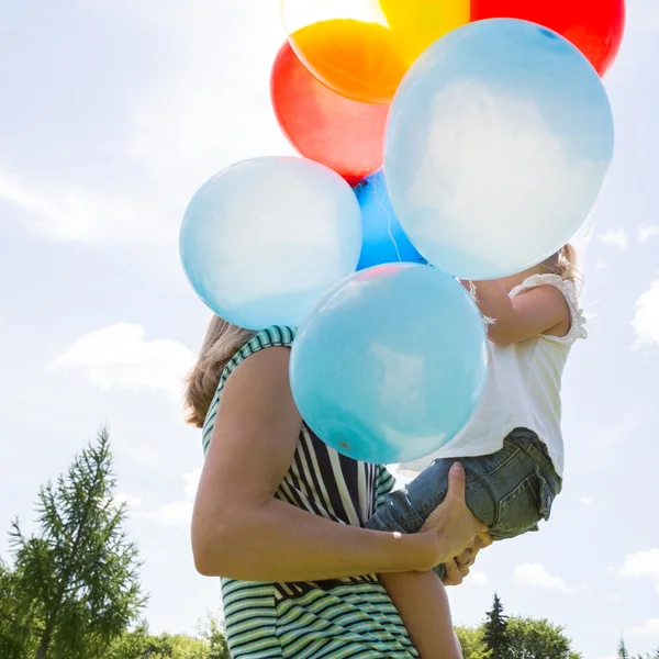 Mor och dotter med ballonger i park — Stockfoto