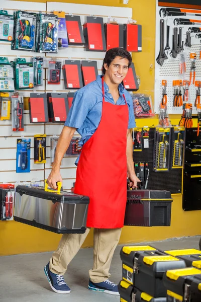 Vendeur portant des boîtes à outils tout en marchant en magasin — Photo