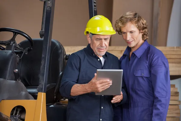 Arbeiter nutzen digitales Tablet in der Werkstatt — Stockfoto