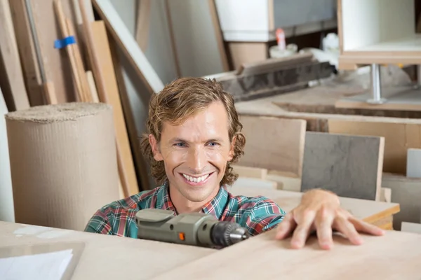 Happy Carpenter Drilling Wood In Workshop — Stock Photo, Image