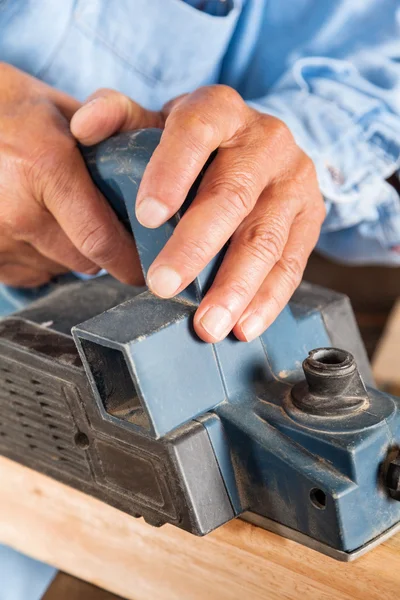 Manos de carpintero Afeitando madera con cepilladora eléctrica — Foto de Stock