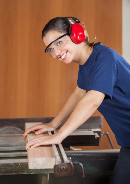 Mutlu kadın marangoz tablesaw kullanma — Stok fotoğraf