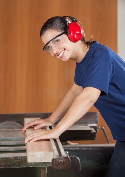 Carpintero femenino feliz usando tablesaw —  Fotos de Stock