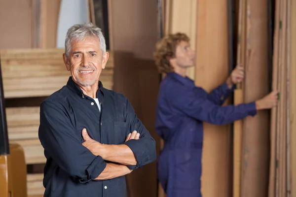 Säker snickare med armar korsade i workshop — Stockfoto