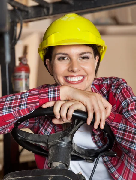 Engenheira feminina apoiada no volante de empilhadeiras — Fotografia de Stock