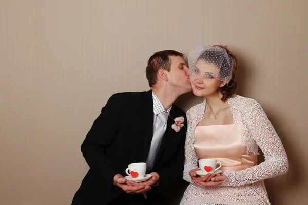 Newly married couple holding a cup with hearts — Stock Photo, Image