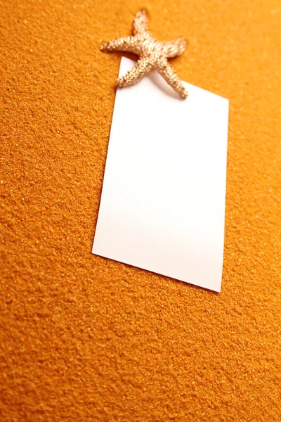 Белая бумага на желтом песке — стоковое фото