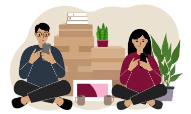 Karşılıklı oturan bir çift cep telefonlarıyla teslimat siparişi veriyor. Karton kutularda bir sürü şey var. Aile başka bir eve taşınmaya hazırlanıyor..