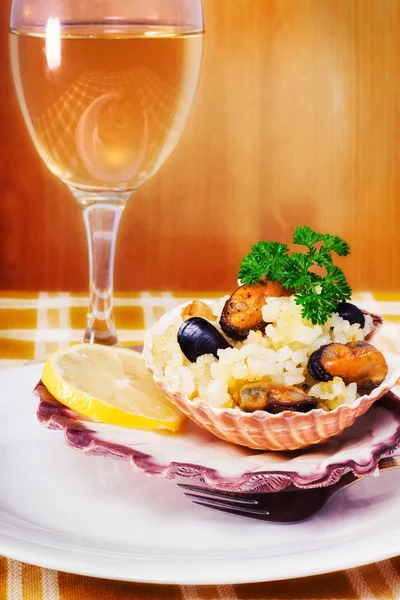 Risotto z owocami morza serwowane w muszla — Zdjęcie stockowe
