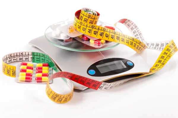 Tape-measure and medicament about kitchen scale — Stock Photo, Image