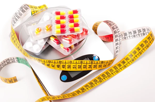 Tape-measure and medicament about kitchen scale — Stock Photo, Image