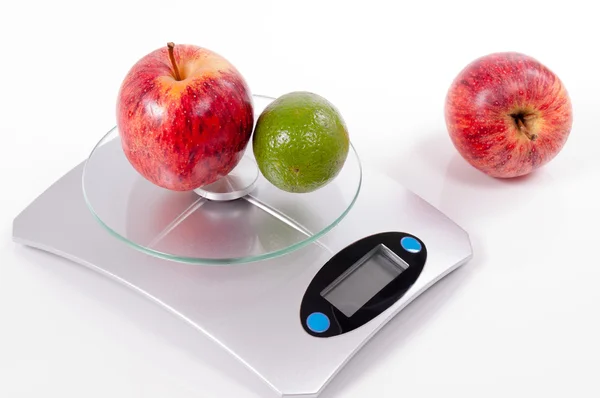 Apple and lemon on kitchen scale — Stock Photo, Image