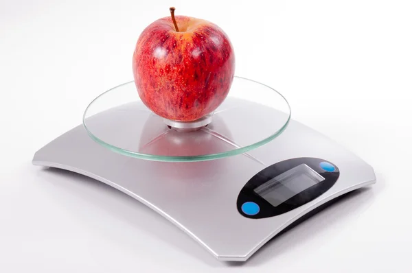 Red apple on kitchen scale — Stock Photo, Image
