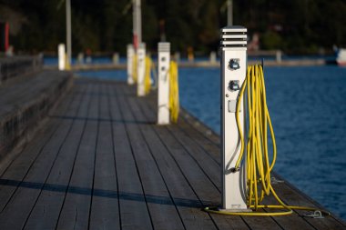 Botlar için şarj istasyonu, marinanın boş limanında yelkenlileri şarj etmek için elektrik prizleri.