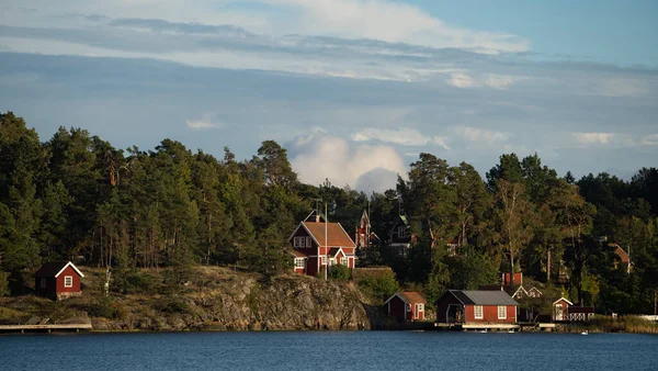 Belle cabane suédoise en bois rouge sur la côte de l'île Rocky en été avec forêt — Photo