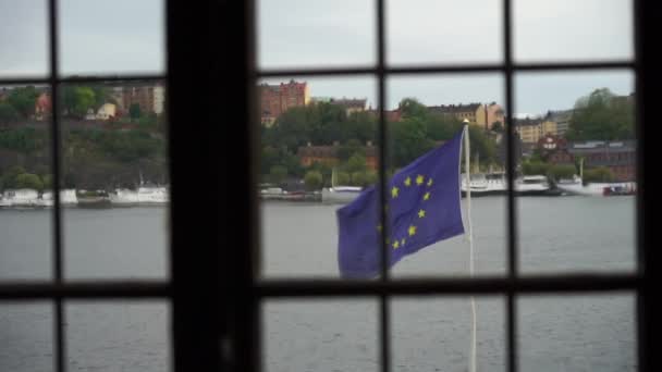 Bendera Uni Eropa pada latar belakang sungai dalam tampilan gerak lambat dari jendela — Stok Video
