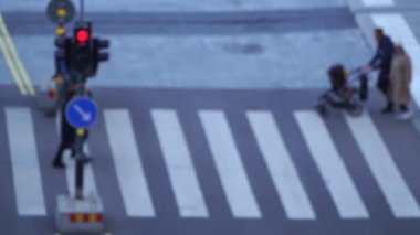 Trafik ışıklarıyla yaya geçidini yavaş çekimde geçen bulanık insanlar. 