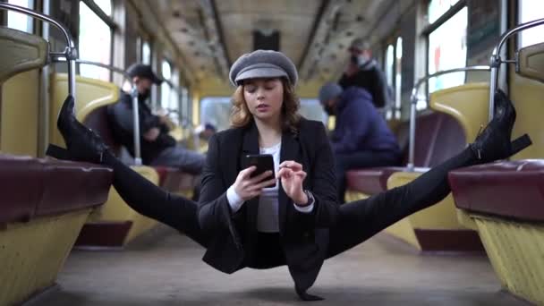 Menina flexível sentado na divisão em carruagem subterrânea com smartphone. Conceito de criatividade, individualidade e autoconfiança — Vídeo de Stock